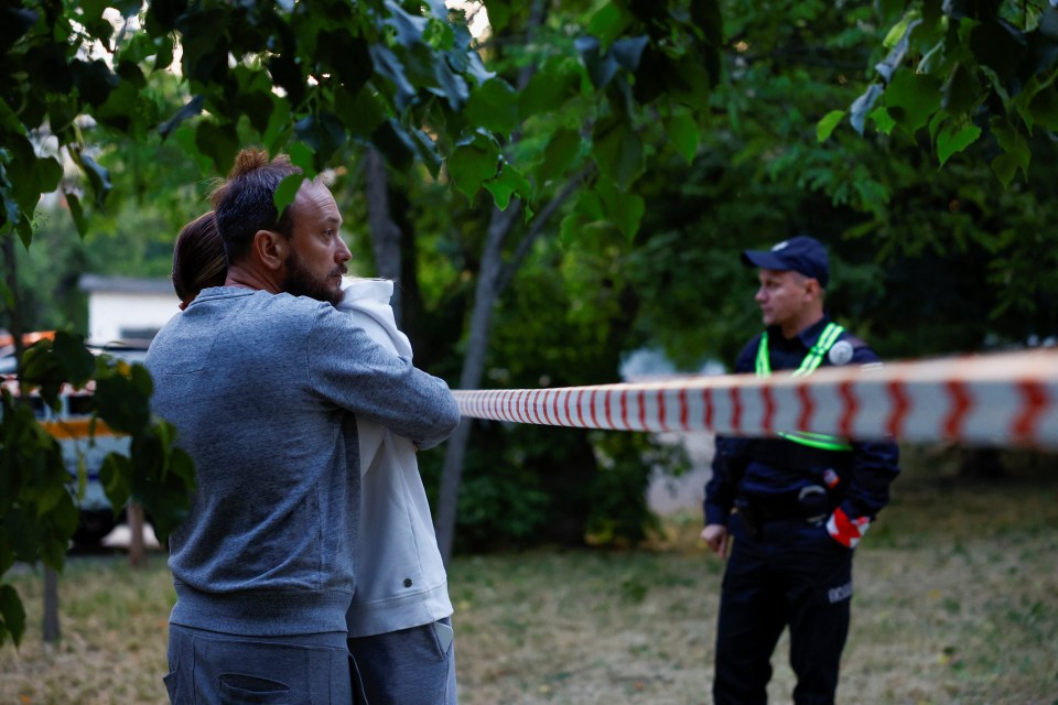 A couple in Kyiv pictured comforting each other following the bombardment