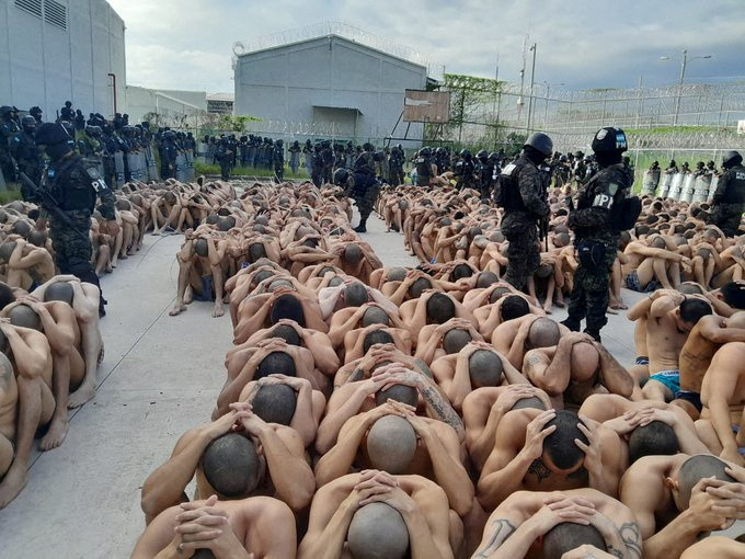 Inmates were sat in rows, spread-legged and nestled against one another