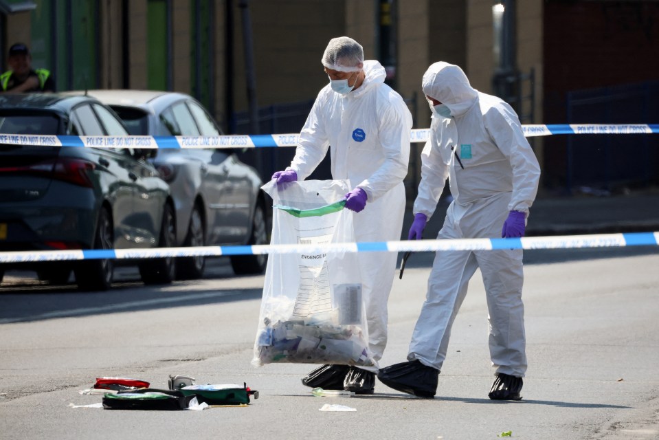 Forensics investigators collect evidence in Nottingham after the attack left three dead