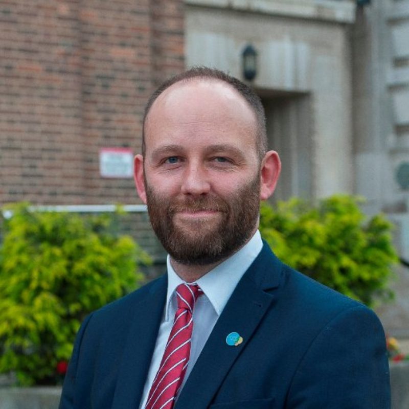 a man with a beard is wearing a suit and tie