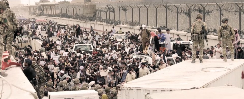 Desperate crowds of Afghans attempt to flee the country by getting on a flight out of the country, as soldiers look on