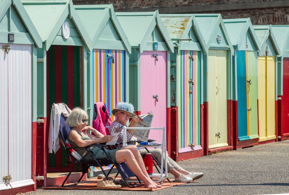 Two women relax on the beach in Hove yesterday