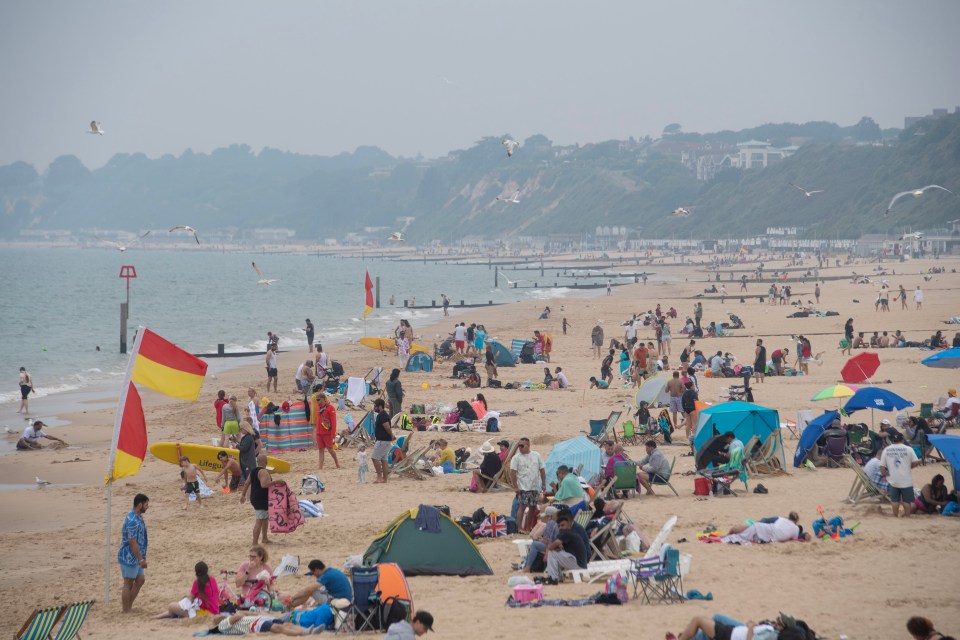 Beach goers at Bournemouth, Dorset make the most of things today although thunderstorms are expected this evening