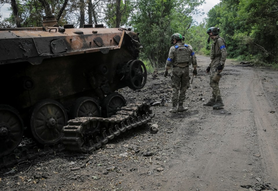 Ukrainian troops check a destroyed Russian BMP-2 infantry fighting vehicle after recapturing several villages in recent days