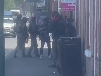 The heavily armed team banged on the door next to a hair salon screaming 'armed police come to the front door now'