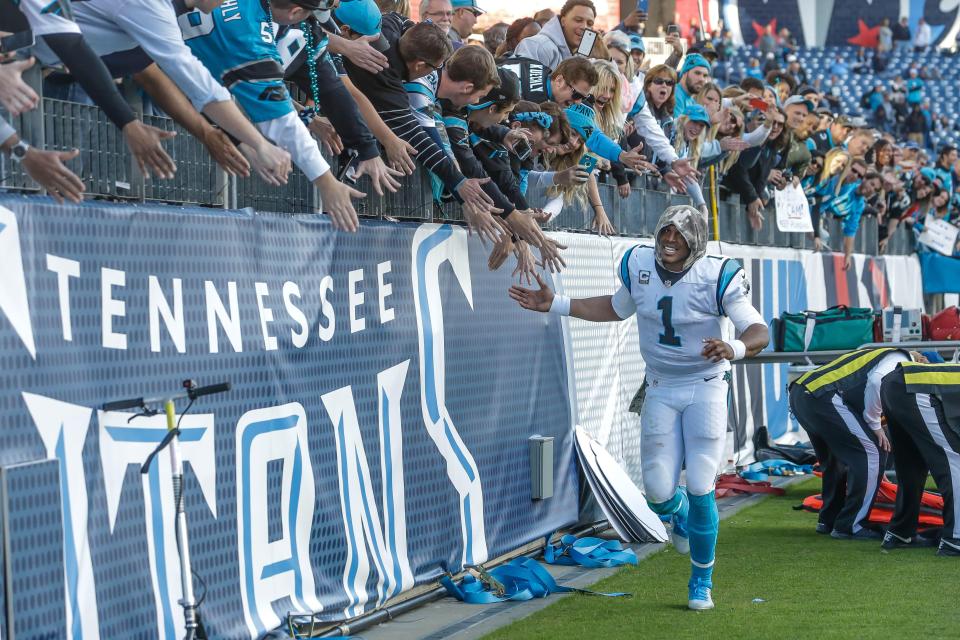 A Titans player celebrates with fans at the football game