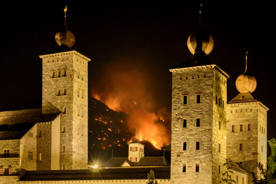 Fires are seen behind the Stockalper palace in Switzerland