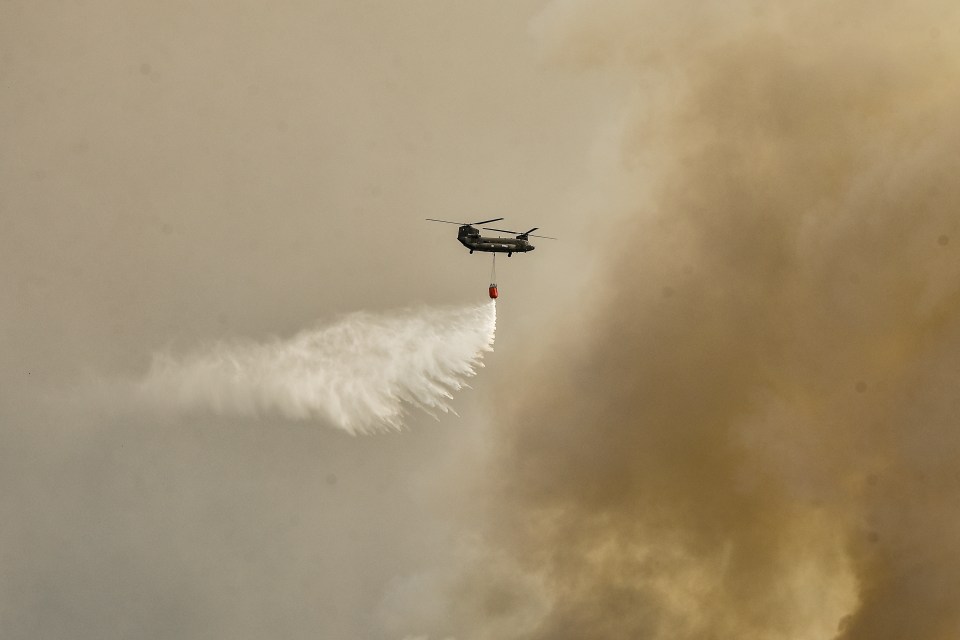 A military Chinook helicopter tries to douse the flames near Athens, Greece