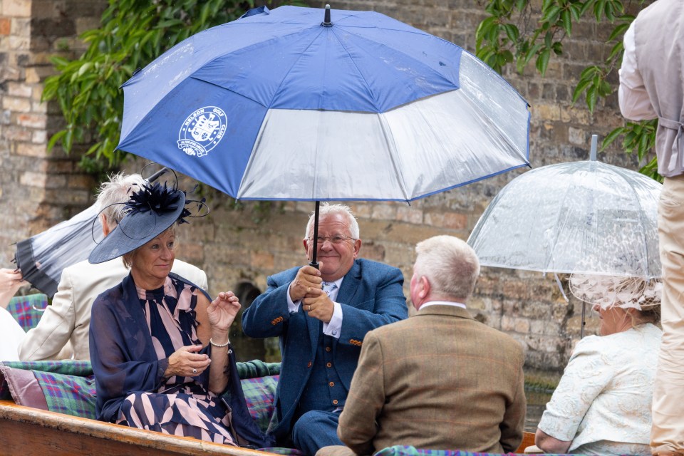 Punters on the River Cam in Cambridgeshire shielding from the rain on Thursday