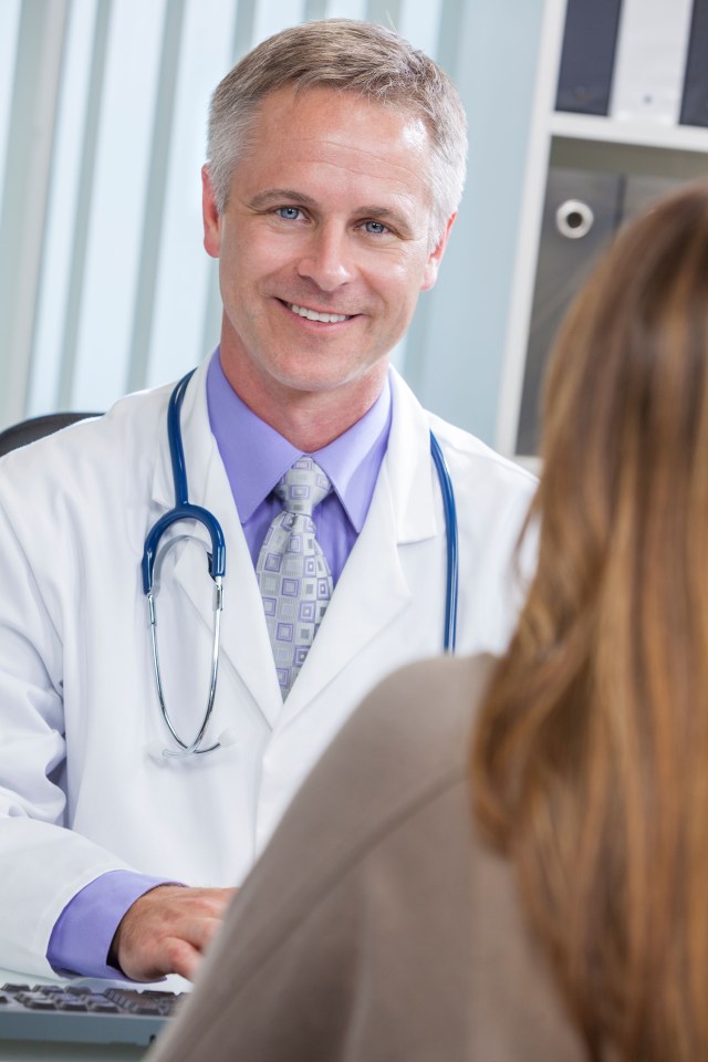 DEM2AK Male medical doctor talking to a female patient in a hospital office