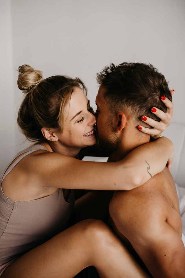 Happy young couple hugging in bed