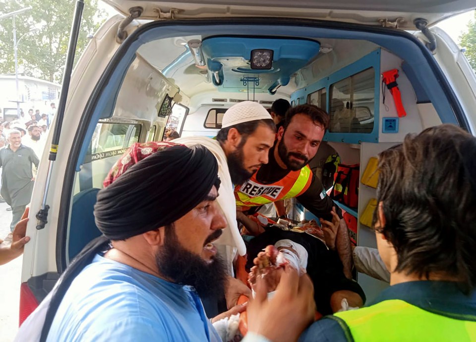 In this photo provided by Rescue 1122 Head Quarters, rescue workers carry a wounded man after a bomb explosion in the Bajur district of Khyber Pakhtunkhwa, Pakistan, Sunday, July 30, 2023. A powerful bomb ripped through a rally by supporters of a hard-line cleric and political leader in the countryÂ’s northwestern Bajur district that borders Afghanistan on Sunday, killing at least 10 people and wounding more, police said. (Rescue 1122 Head Quarters via AP)