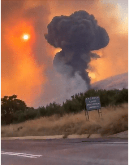 A mushroom cloud of smoke rises above the site