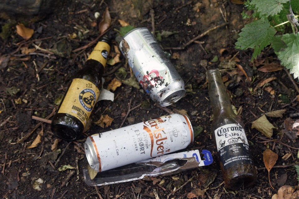 Empty alcohol cans are littered around an entrance used to get into the building site