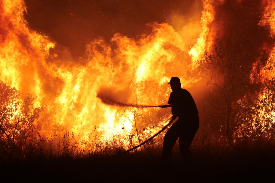 A firefighter battles a blaze in the Volos region