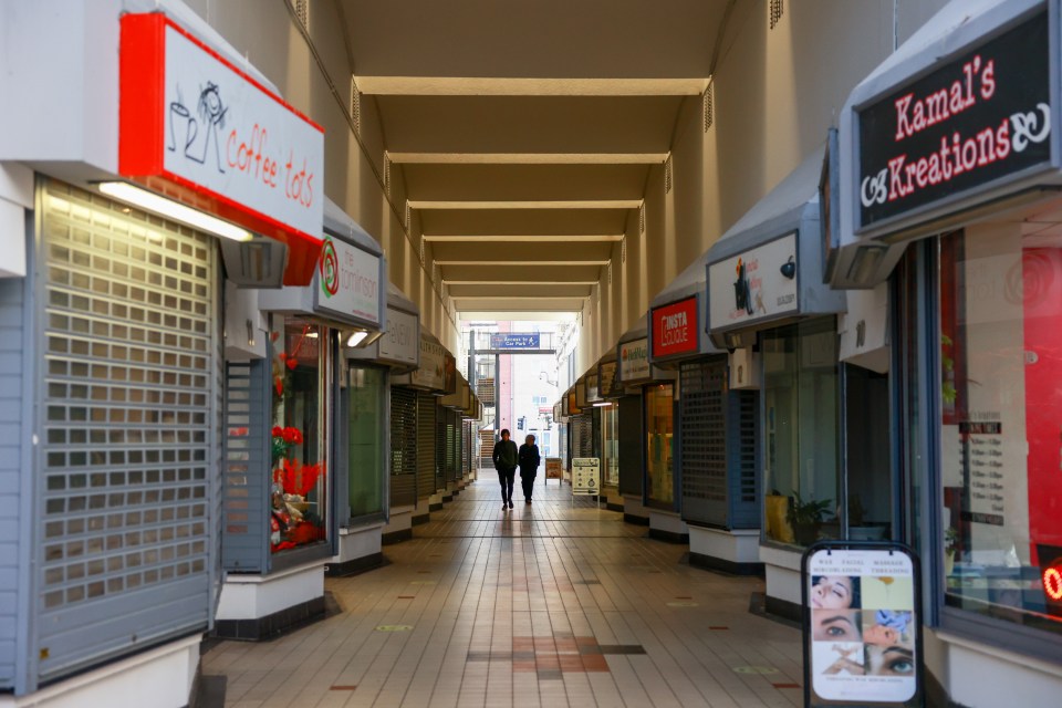 Two shoppers walk through the deserted mall