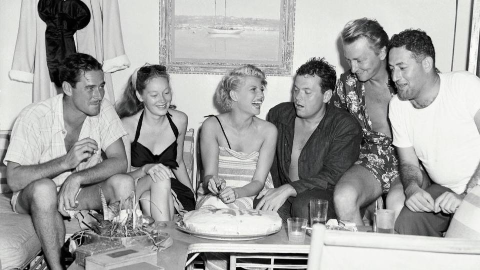 Errol Flynn, left, hosted a birthday party on his yacht for Rita Hayworth, centre with her husband Orson Welles, in 1946