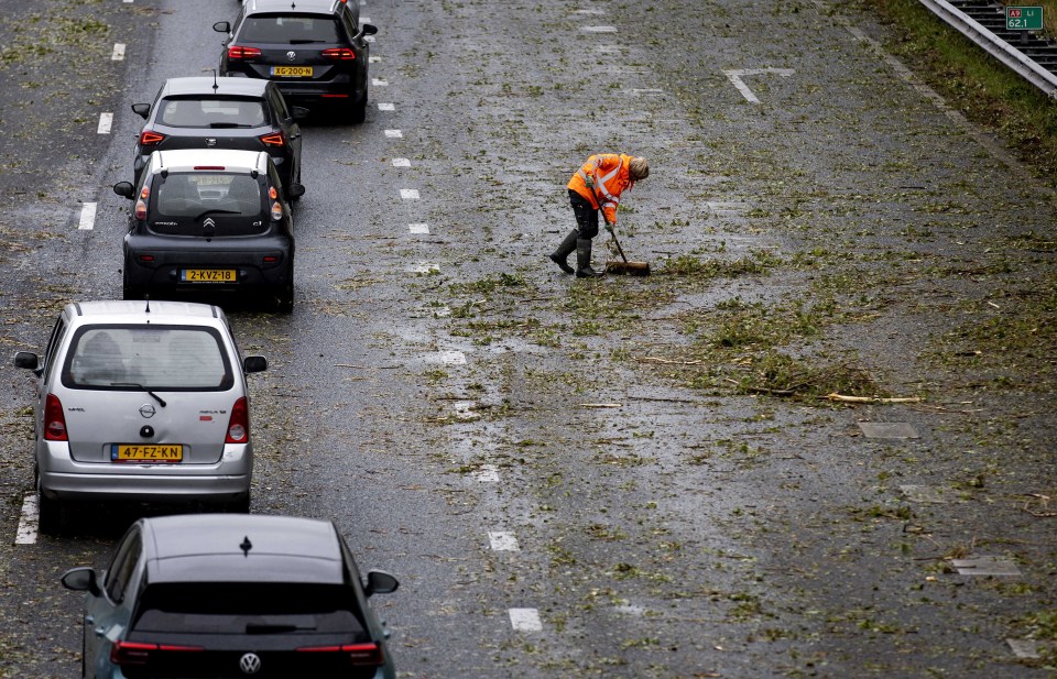 A worker cleaning dirt blown onto a highway near Uitgeest, The Netherlands, today