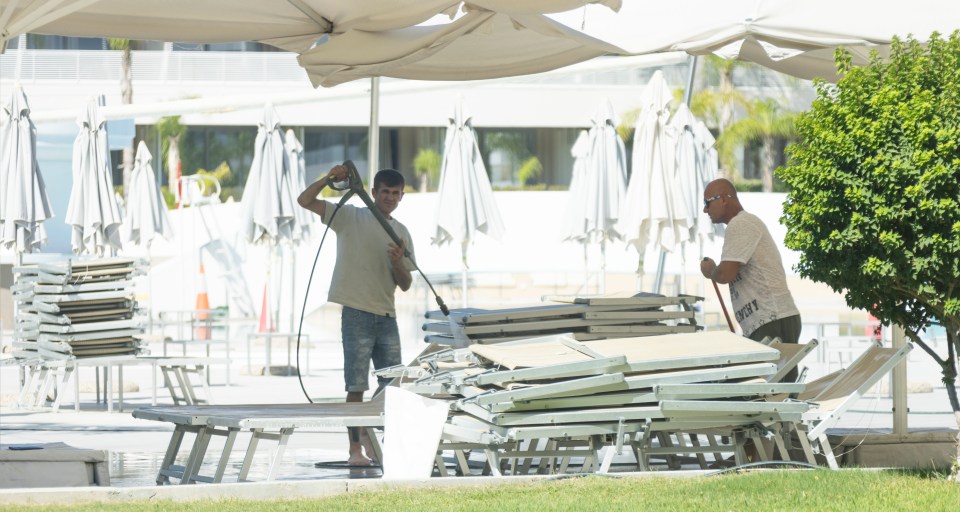 Staff with pressure washers clean at the Princess Adriana after the fires