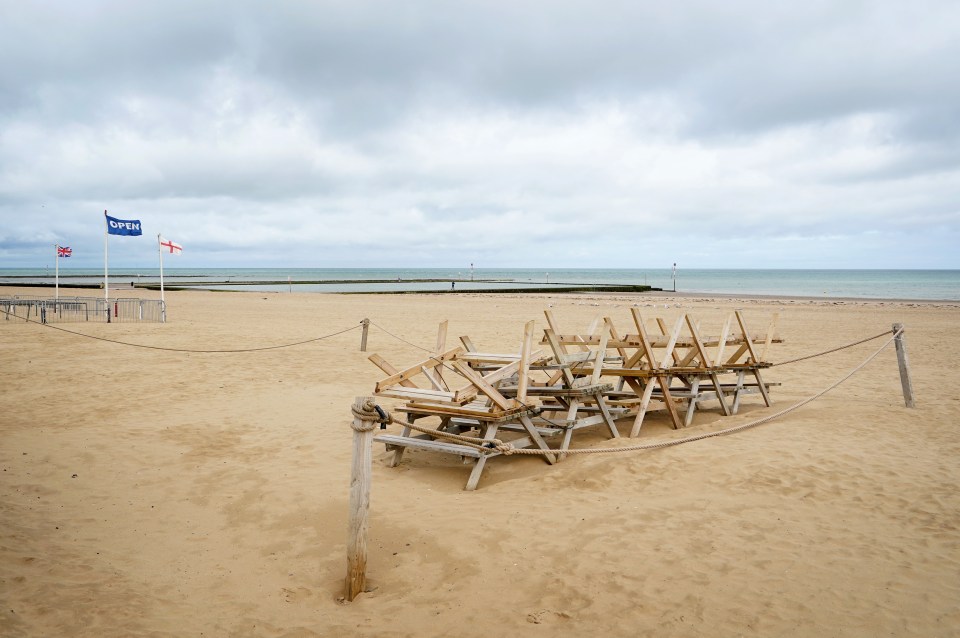 Empty benches are stacked up under a stormy sky on Margate Beach, Kent, as the weather rolled in on Monday