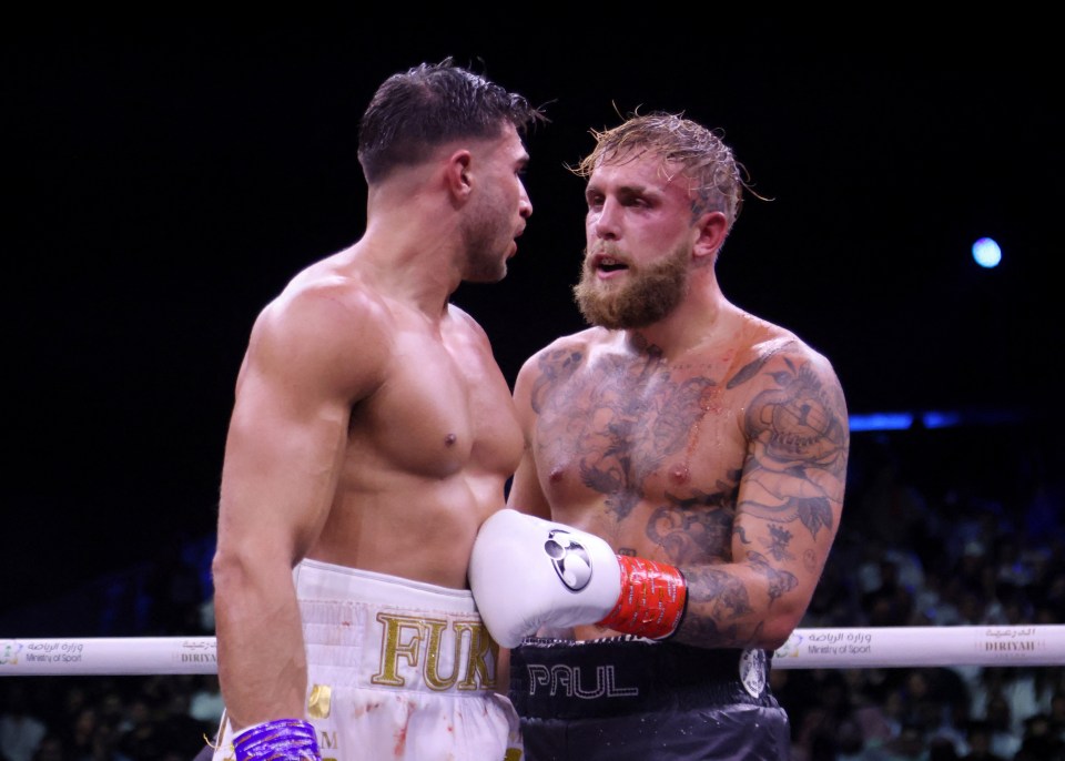 two boxers one of whom is wearing a belt that says paul