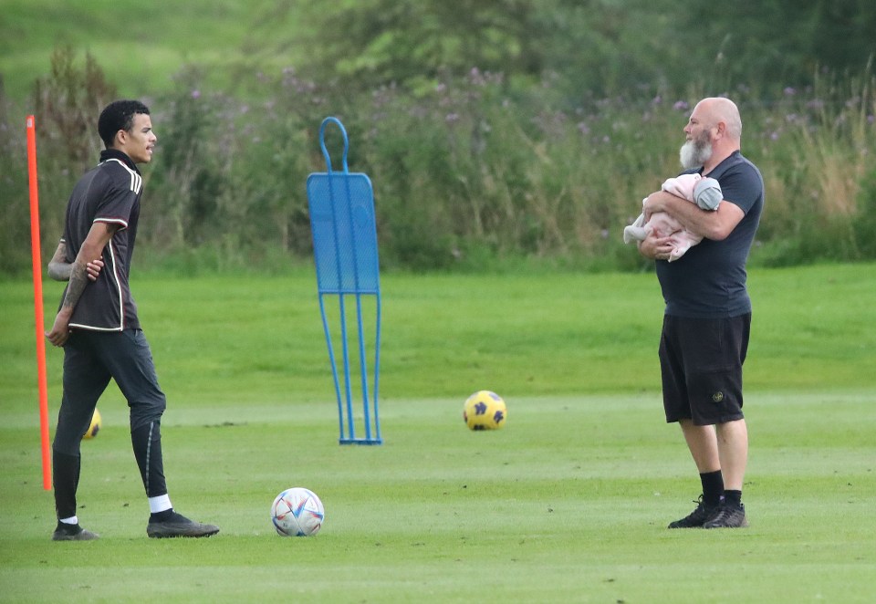 The young forward was pictured training while his dad cradled his daughter