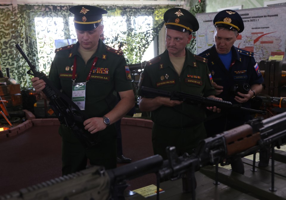 Russian Army officers examine assault riffles, claimed to be captured in Ukraine