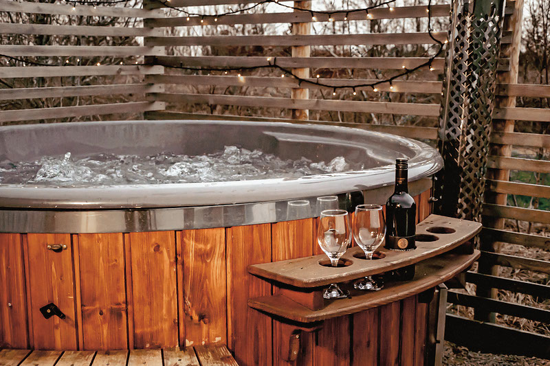 Unwind in an outdoor hot tub while watching the sheep stroll across the fields