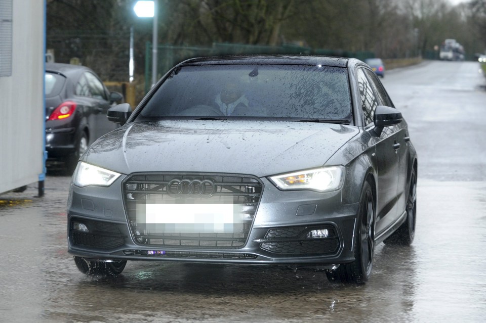 a gray audi car is driving down a wet road