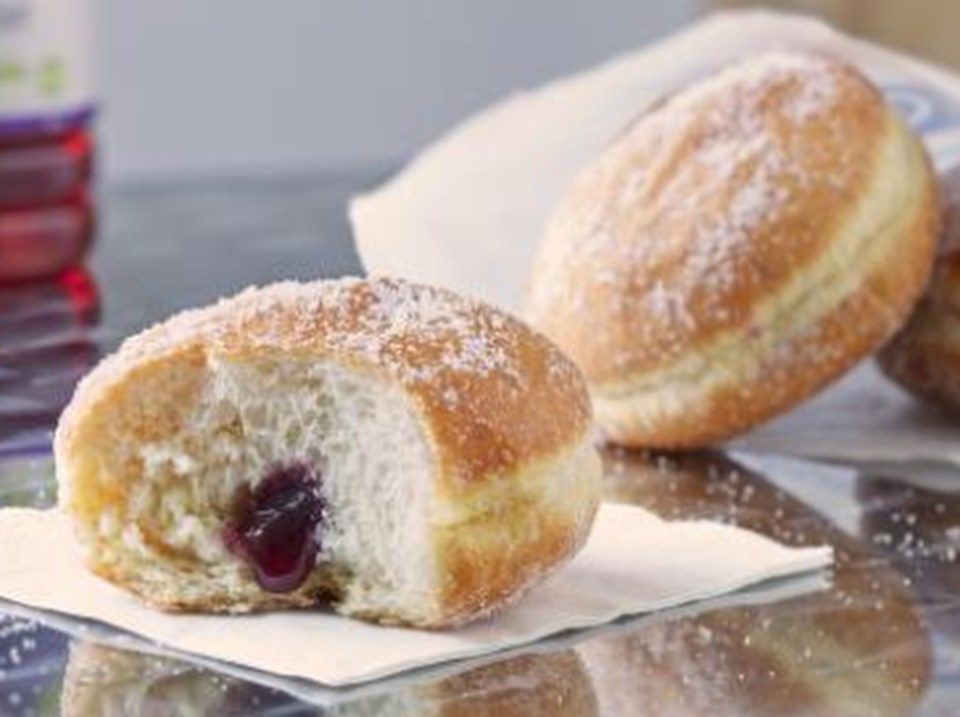 a donut with a bite taken out of it is sitting on a napkin on a table .