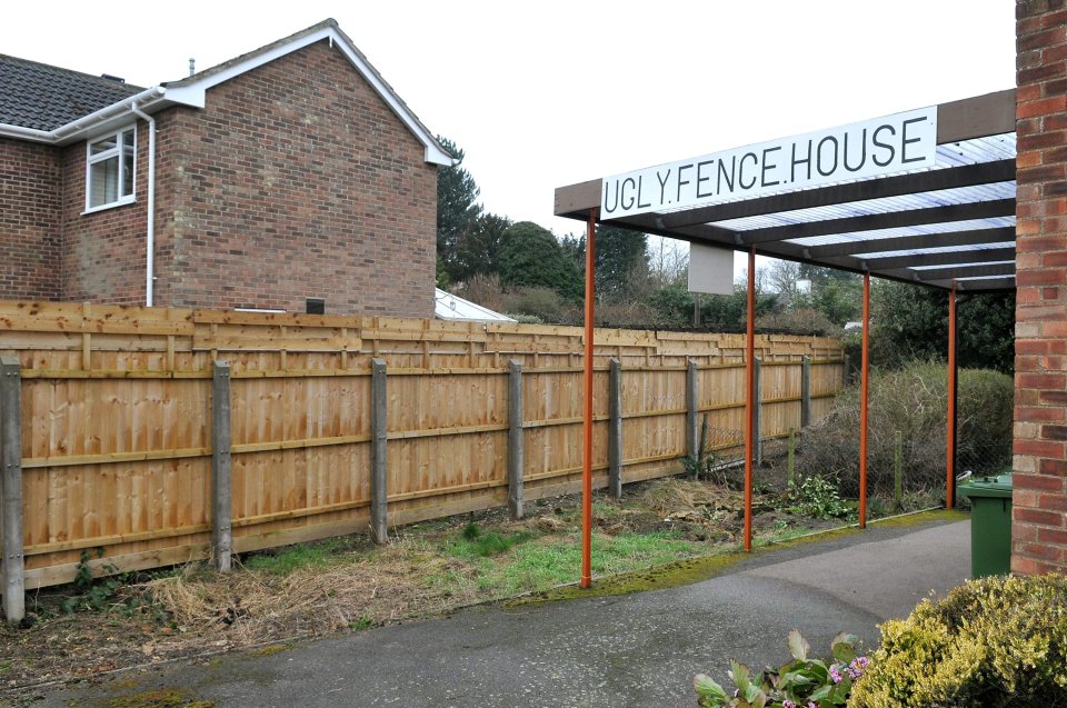 The fence ran high above Mr Bentley's one - so he put up a sign blasting the Laws' 'Ugly fence house.