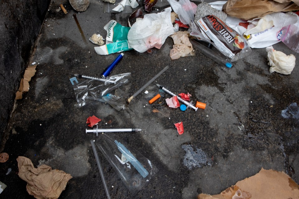 Used needles are seen littering a New York homeless camp