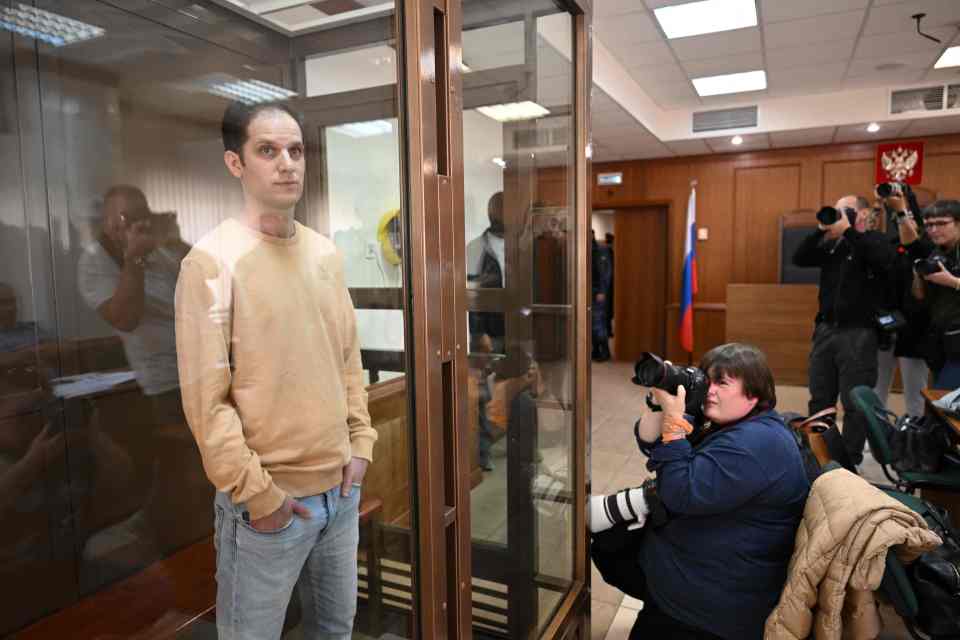 The wrongly detained journalist stood tall behind his glass cage