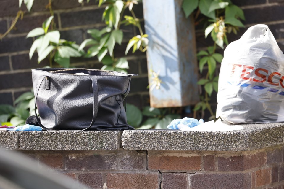 Personal belongings lie on the floor near the bus stop