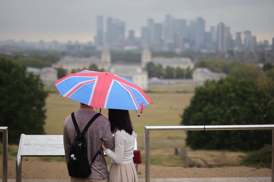 The public attempt to shelter during heavy rain in Greenwich Park, south east London, on Sunday