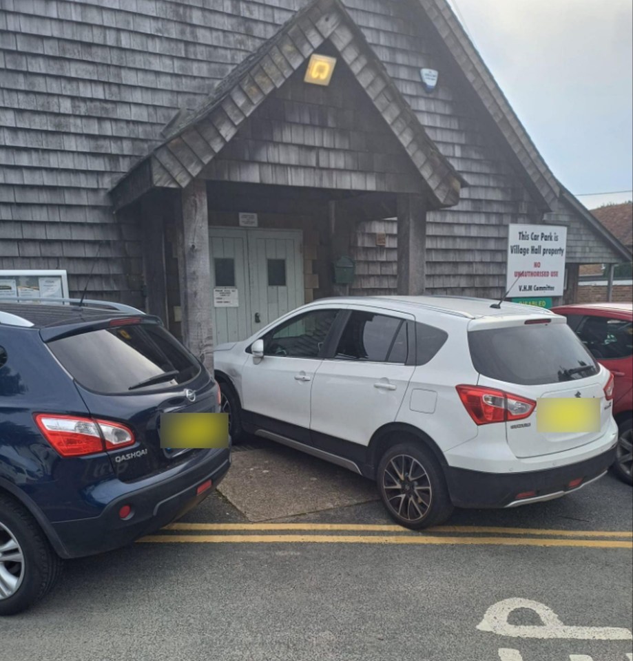 A white Suzuki blocks the entrance to the Wigham Village Hall