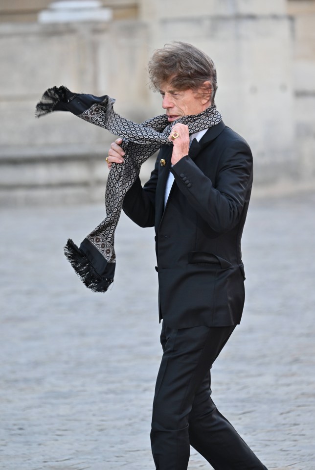 A windswept Mick Jagger battles with his scarf ahead of the banquet