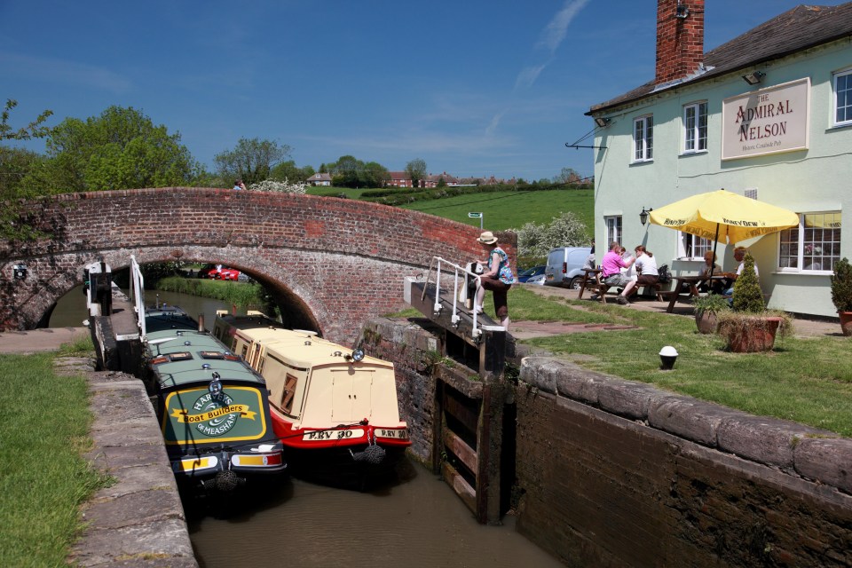 EEXT7E Two narrowboats entering double lock no. 3 on the Grand Union Canal by the Admiral Nelson pub at Braunston