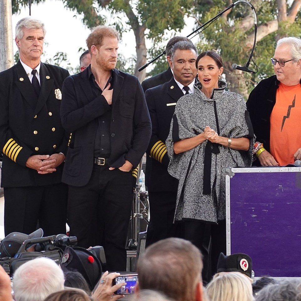 a group of people standing in front of a microphone with one man wearing an orange shirt with a lightning bolt on it