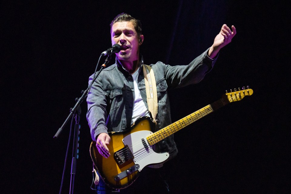 Isaac Hanson rocked out on his guitar as Hanson supported Busted