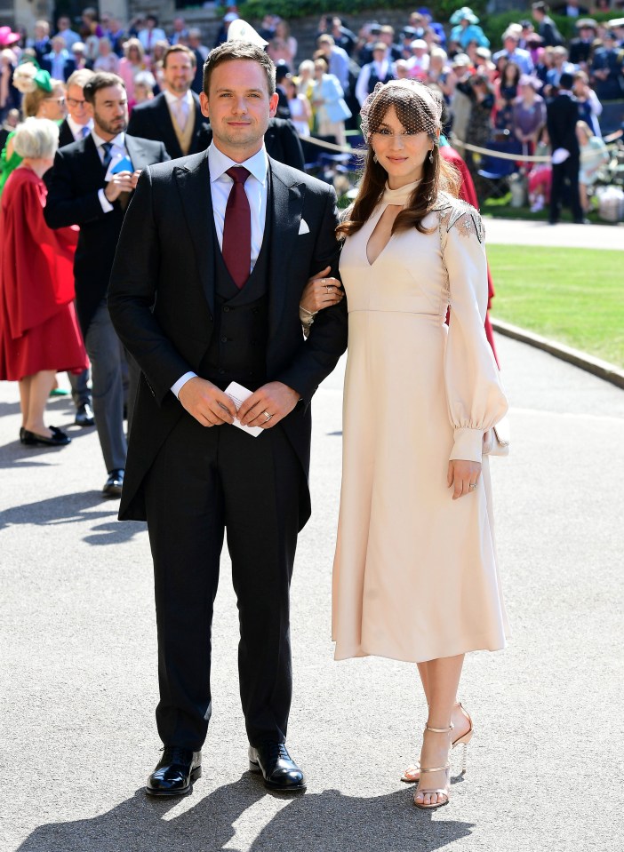 a man in a suit and tie stands next to a woman in a white dress