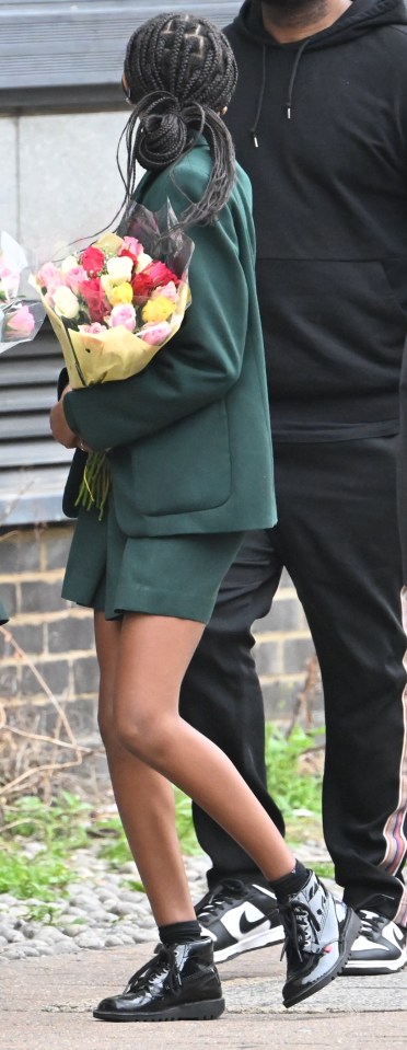 A pupil is seen carrying flowers to lay for the victim, named locally as Eliyanna