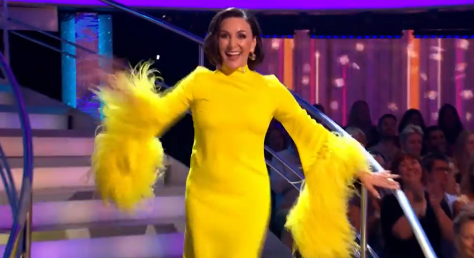 Shirley wore a bright yellow dress with dramatic feather sleeves