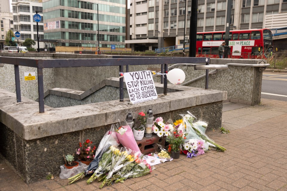 Flowers have been laid alongside signs calling for an end to the violence