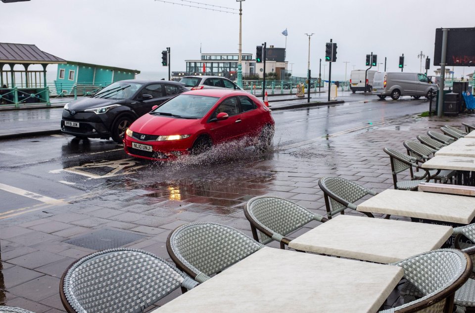 Cars make their way through deep puddles in Brighton on Friday