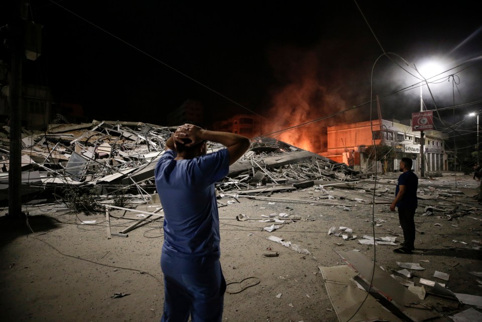 Two Palestinian men look at the aftermath of an Israeli hit in Gaza City