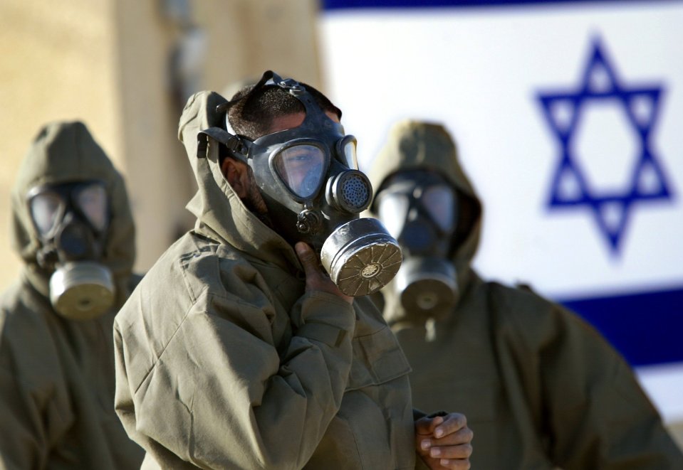 Israeli soldiers wear their gas masks and chemical suits during training