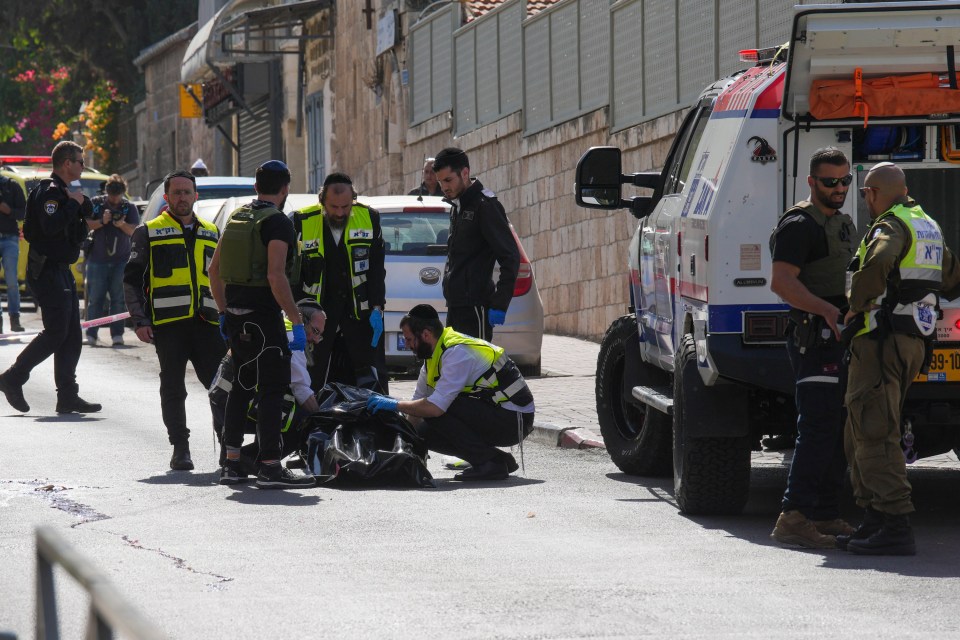 Armed cops crowd around the body of the dead teen knifeman