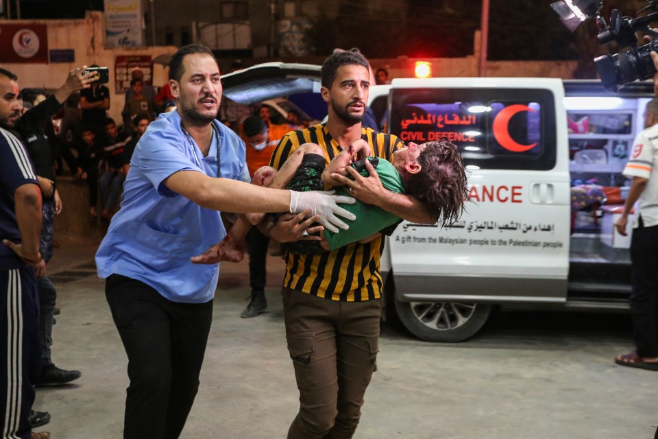 A man runs to a hospital with a wounded child