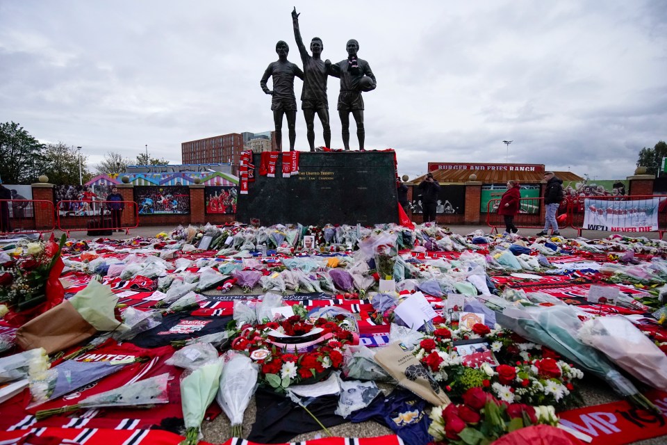 Flowers, scarves and photographs were placed outside Old Trafford ahead of the match this evening